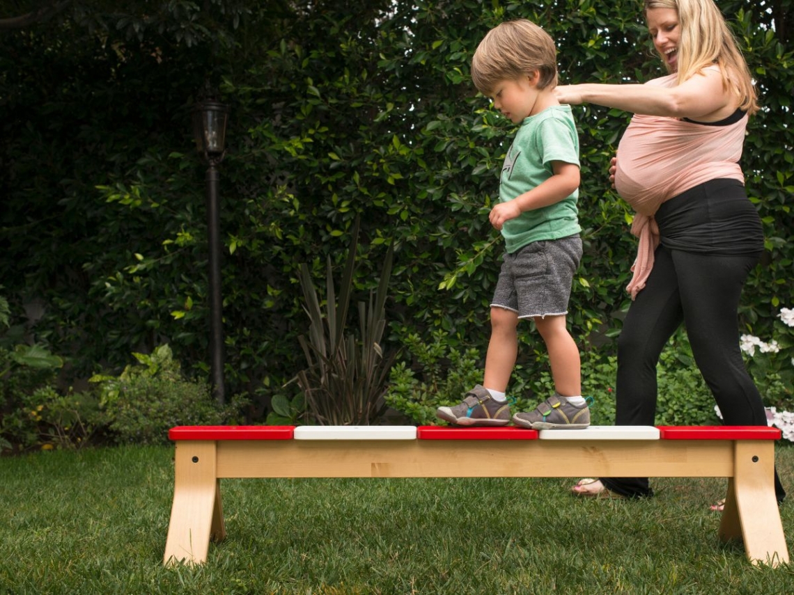 a mother helping her son on a balance beam.jpg